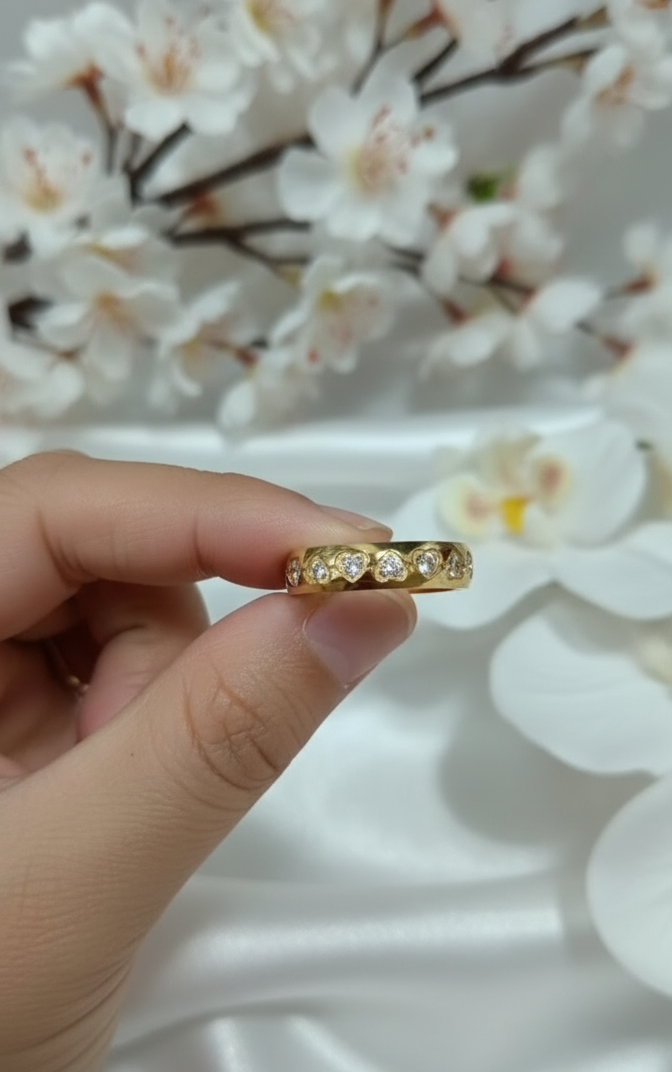 Gold ring with diamonds on a finger against a white background
