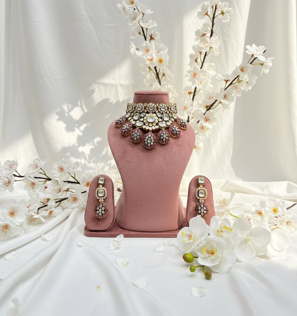 Jewelry set including a necklace and earrings on a pink mannequin bust.