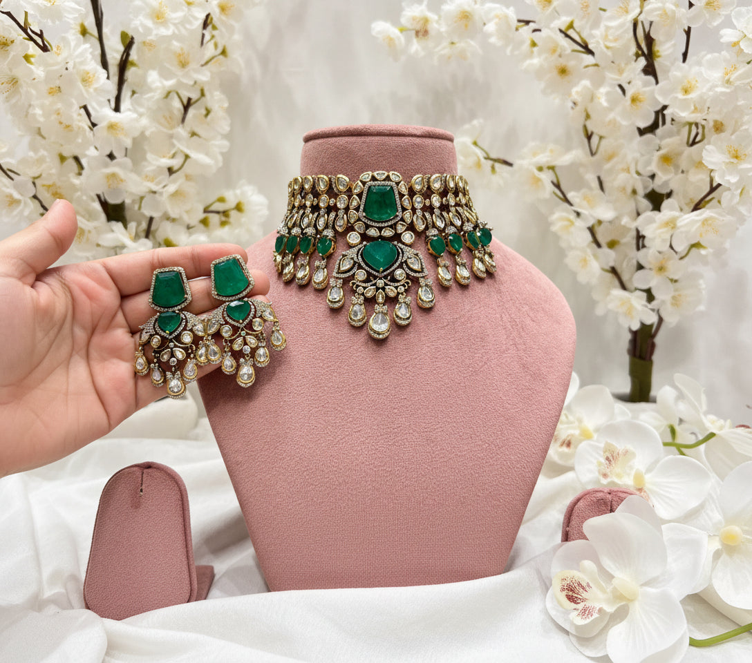 Jewelry set with green stones on a mannequin bust in a store setting.