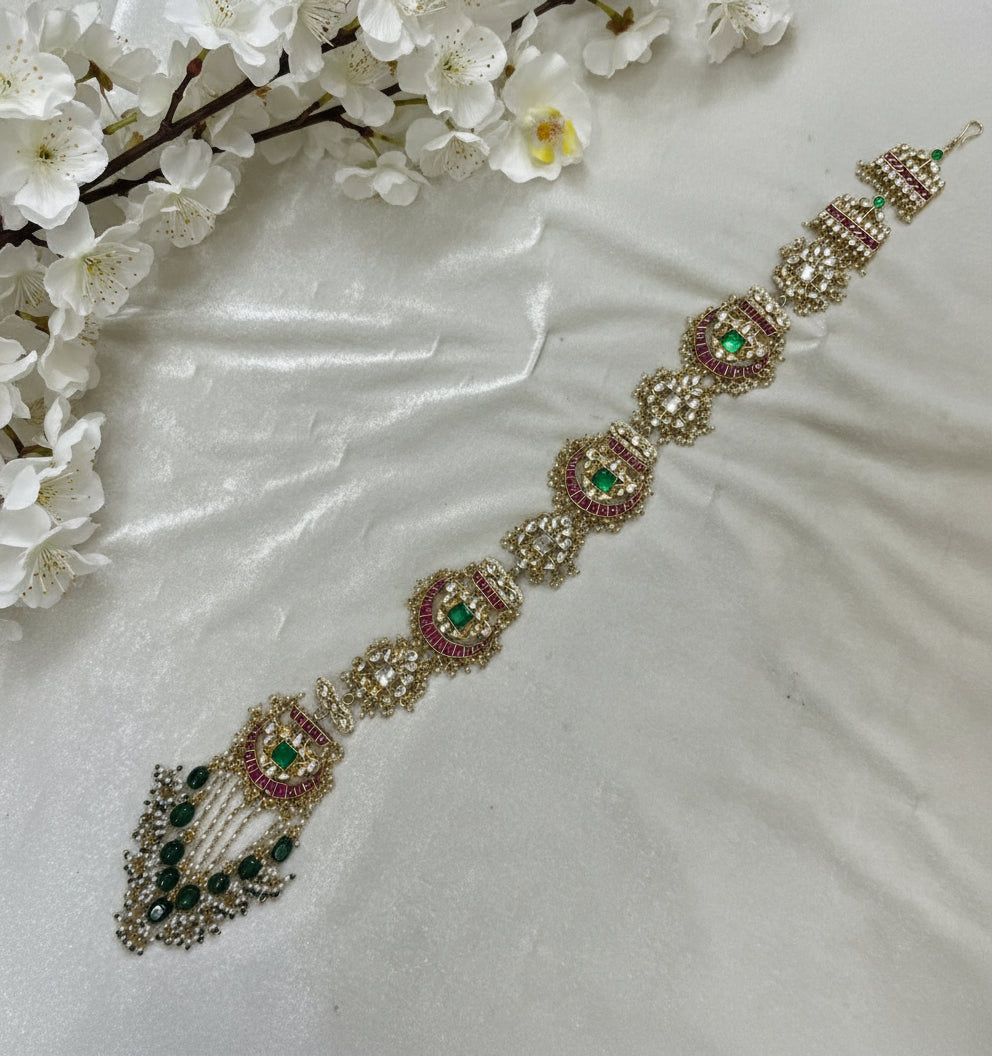 Decorative bracelet with gemstones on a light fabric background with white flowers.